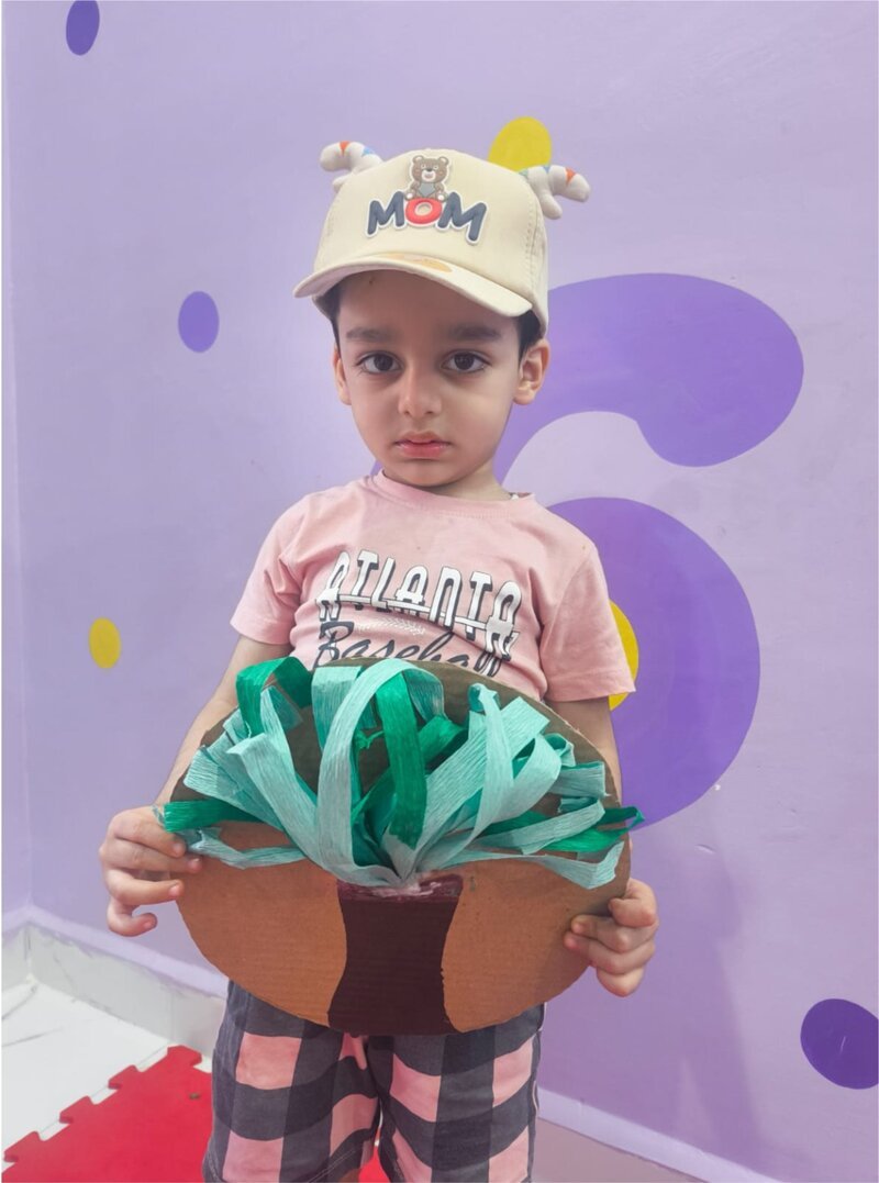 A little artist with his craft-paper tree — the printed coloring-book page